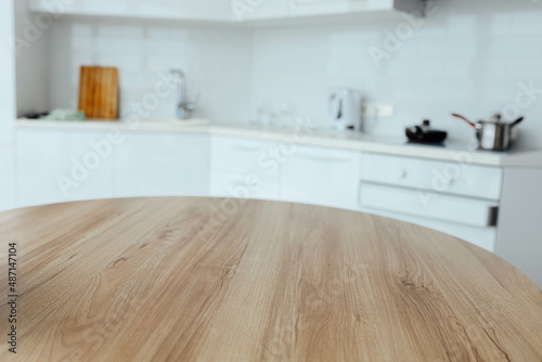 wooden table on the background of a white modern kitchen, a place for food, goods.