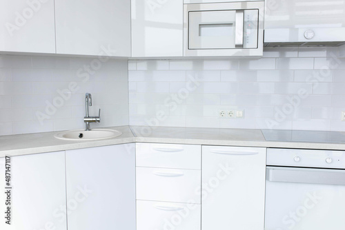 modern white kitchen interior  functional lacquered kitchen furniture  built-in appliances.