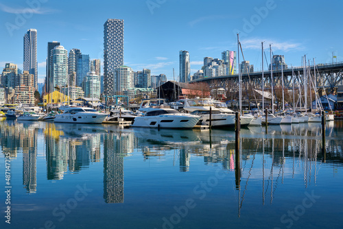 Vancouver, British Columbia, Canada – February 13, 2022. Granville Island Marina Blue Sky Reflections. Yachts in Granville Island Marina on a sunny afternoon. Vancouver, British Columbia, Canada.