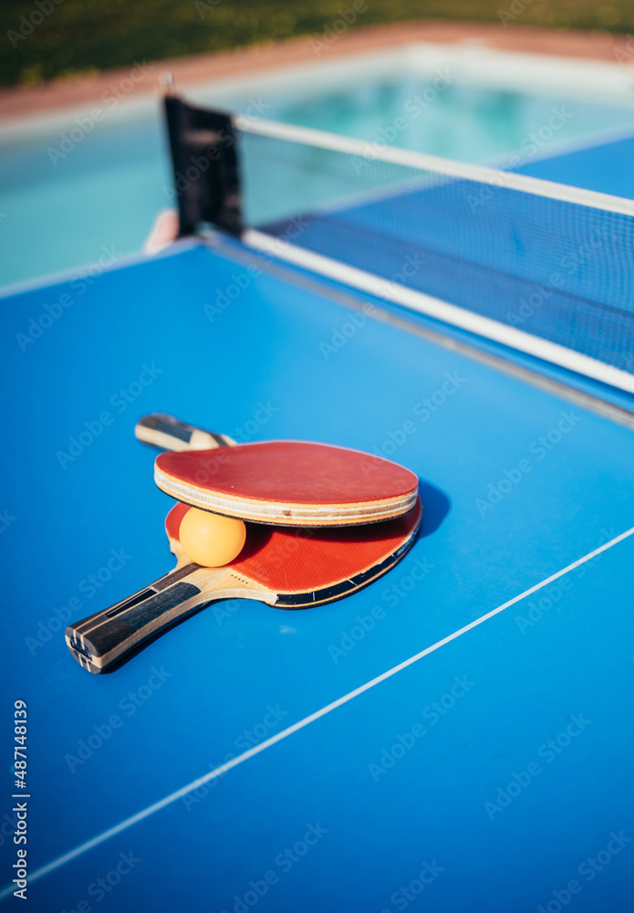 Close up of ping pong or table tennis rackets near a swimming pool. Summer  and vacation concept. Photos | Adobe Stock
