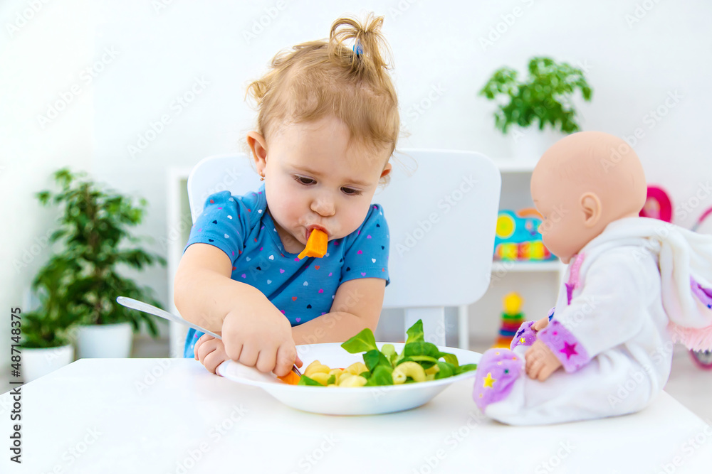 Child baby eats pasta with vegetables. Selective focus. Child baby eats pasta with vegetables. Selective focus.