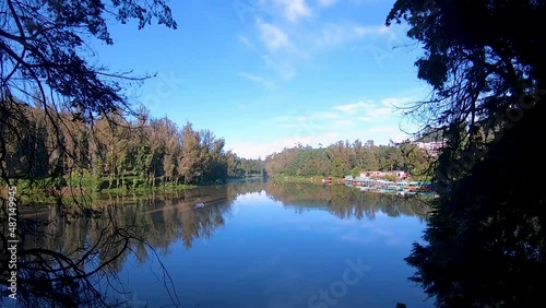 pristine calm water lake with reflection of soothing blue sky and surrounded by green forests video taken at ooty lake tamilnadu india. photo