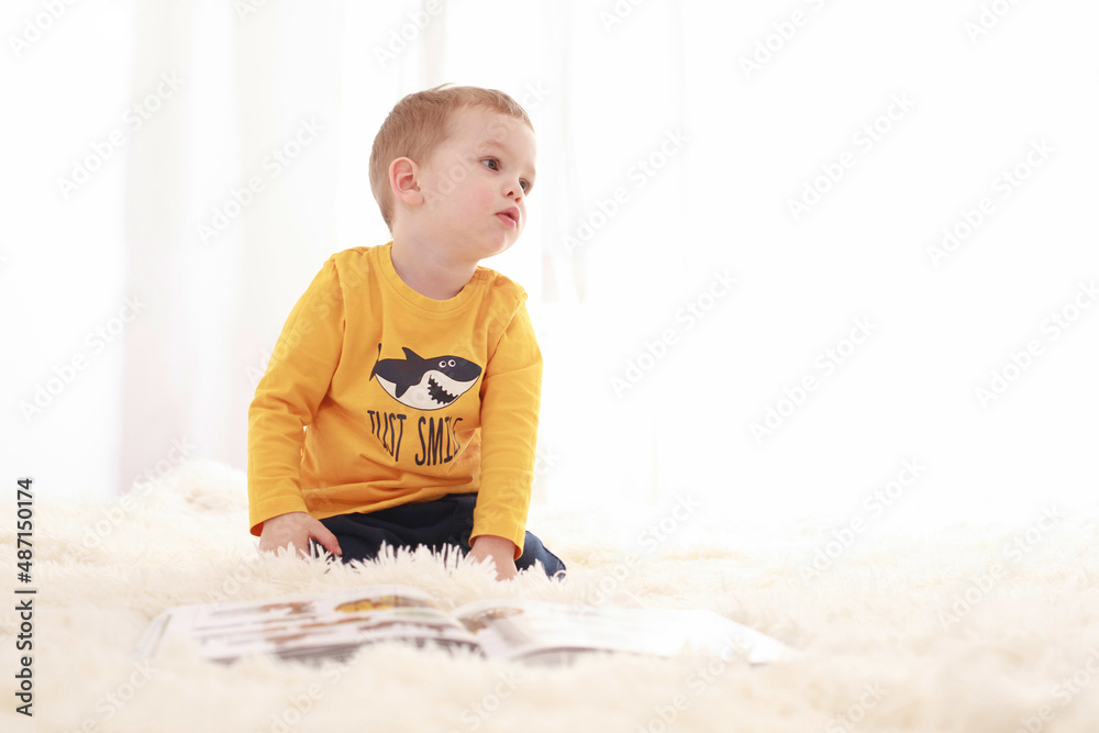 3 year old baby sitting on a white fluffy blanket in a white room and looking around happily
3 year old baby sitting on a white fluffy blanket in a white room and looking around happily