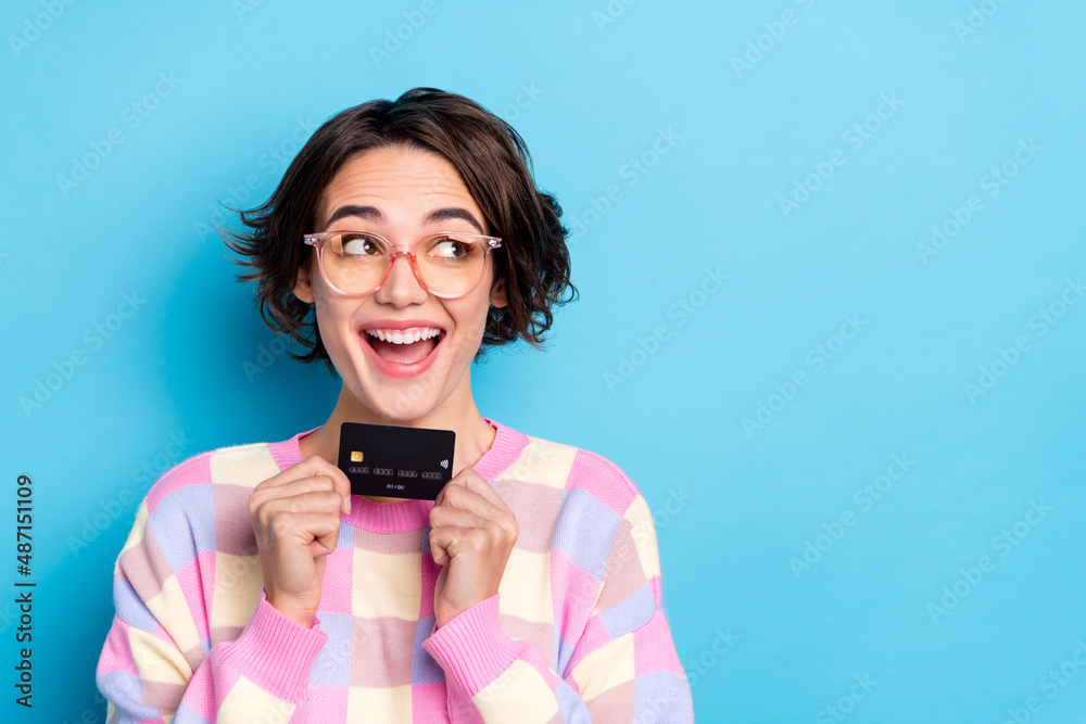 Photo of cool millennial brunette lady hold card look promo wear eyewear plaid pullover isolated on blue background Photo of cool millennial brunette lady hold card look promo wear eyewear plaid pullover isolated on blue background