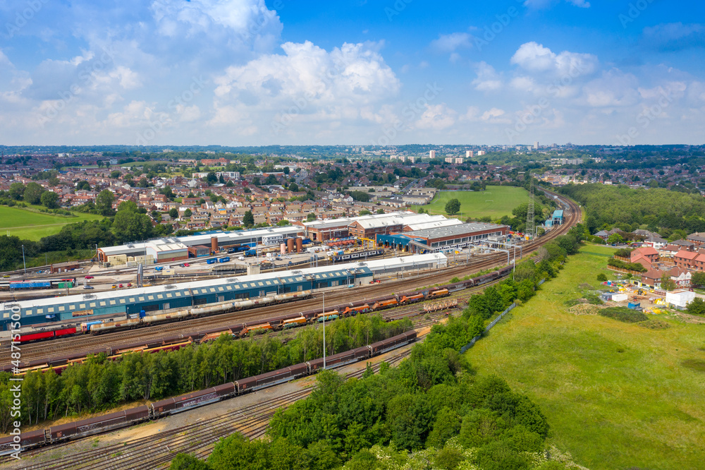 Aerial Photo of a train station works depot with lots of trains in the tracks located in the village of Halton Moor in Leeds, West Yorkshire in the UK on a bright sunny summers day.