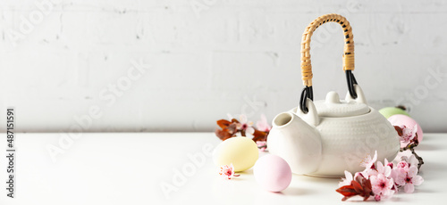 Photography Easter composition with White ceramic teapot, Easter eggs and spring flowers on