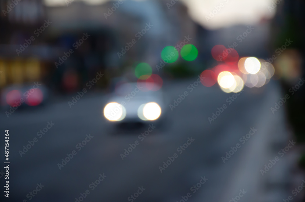 Defocused receding city traffic in the evening. Out of focus lights of traffic jam on city street. City blur background. Moving bokeh circles of evening traffic.