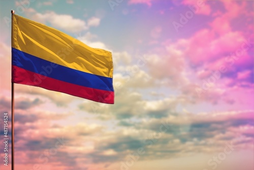 Fluttering Colombia flag mockup with the space for your content on colorful cloudy sky background.