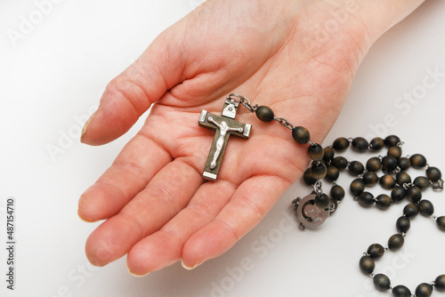 A woman holds a holy rosary in her palm. Catholic. Prayer time