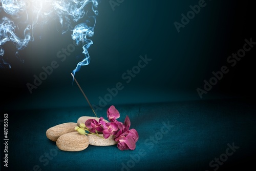 sacred incense stick on a background with a fire and a lot of smoke. The concept of incense, healing, meditation, relaxation, tranquility, calming.
