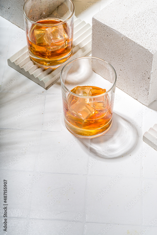 Alcoholic drink, cold summer hard strong alcohol cocktail, whiskey with ice in short glasses on white background