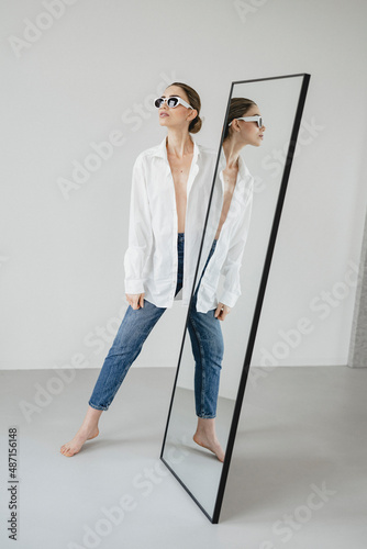 Attraktive, Junge Frau spiegelt sich in körpergroßem Spiegel