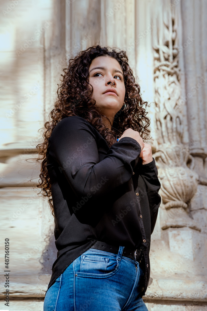 Portrait of a pretty young girl with curly hair in elegant clothes outdoors Portrait of a pretty young girl with curly hair in elegant clothes outdoors