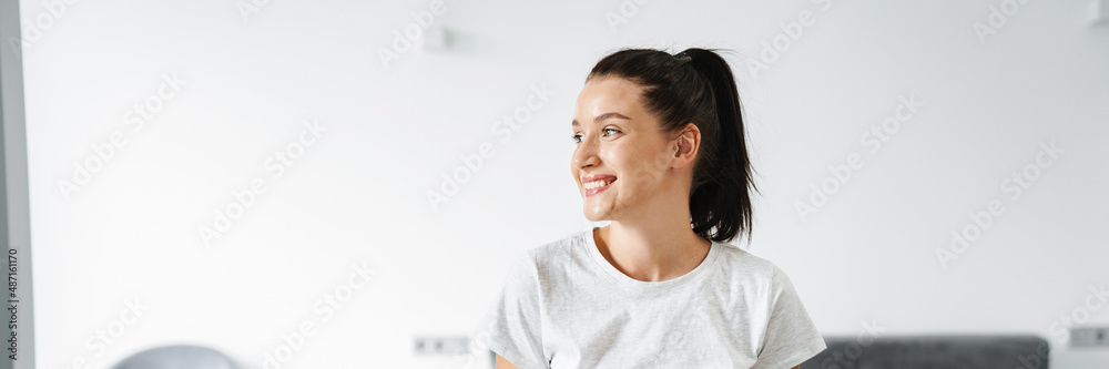 European smiling woman using mobile phone while sitting on couch European smiling woman using mobile phone while sitting on couch