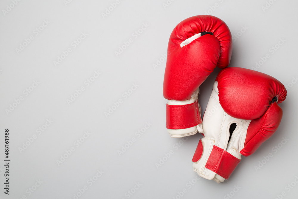 Pair of red boxing gloves on color background. Top view.