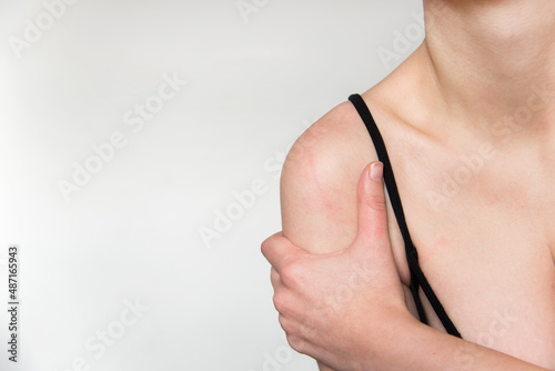 Detalle de una mujer tocando su hombro. Concepto de dolor de articulaciones photo