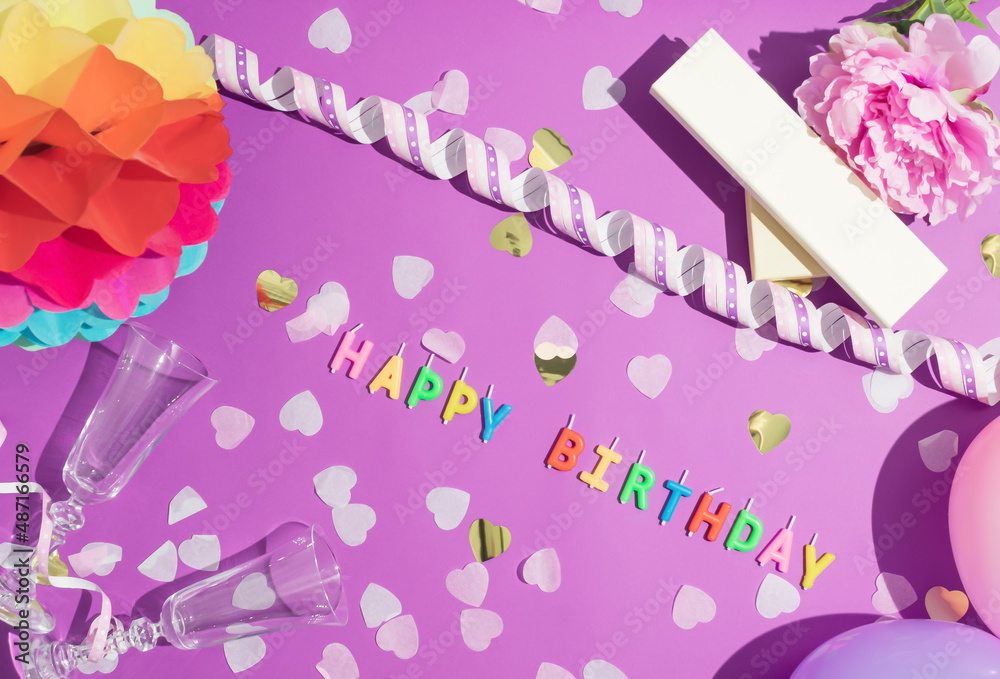 Colorful Happy Birthday candles and confetti on purple background, top view. Festive or party background. Flat lay style. Birthday greeting card. Colorful Happy Birthday candles and confetti on purple background, top view. Festive or party background. Flat lay style. Birthday greeting card.