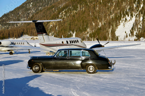 A vintage car and private jets in the airport of Engadine St Moritz