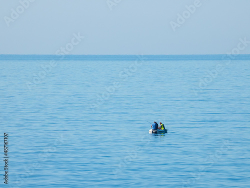 Three men on a boat are fishing in the Mediterranean Sea