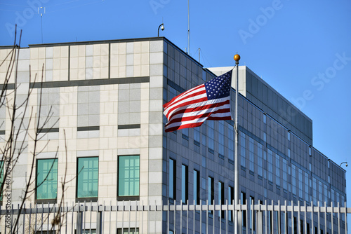 An american flag waves in the wind.  A view of the Embassy of the United States of America in Kyiv, Ukraine photo