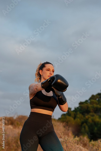 fit young girl with boxing gloves outdoors