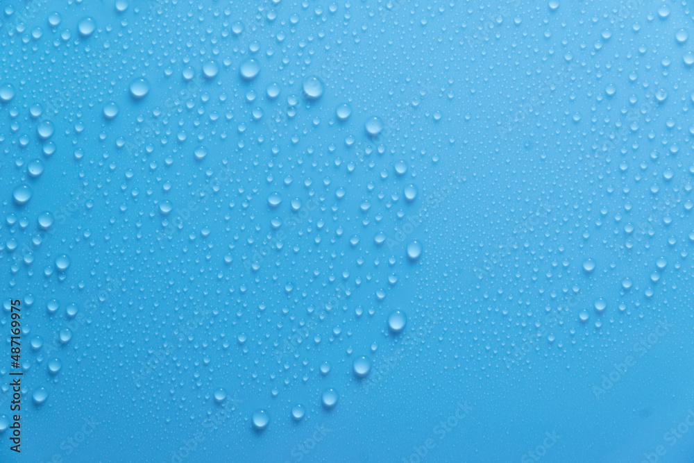 Blue pastel water drops on light shiny surface