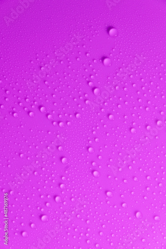 Violet pastel water drops on light shiny surface