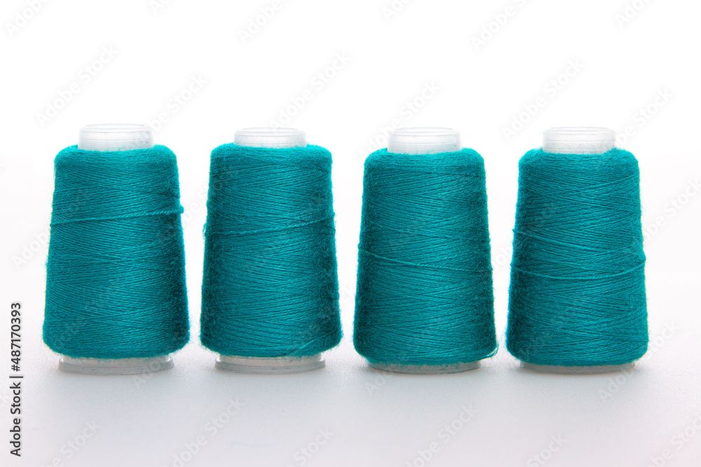 Green spool of thread isolated on white background. Skein of woolen threads. Yarn for knitting. Materials for sewing machine. Coil Green spool of thread isolated on white background. Skein of woolen threads. Yarn for knitting. Materials for sewing machine. Coil