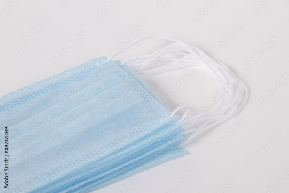 Blue disposable surgical face mask top view. Protective mask with ear straps against coronavirus and bacteria isolated on white background. Healthcare medical hygiene concept