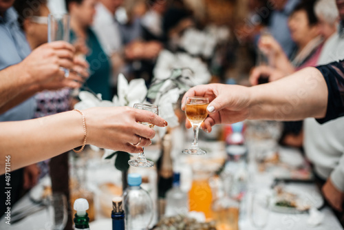 Russian wedding, guests hold glasses with alcohol and are being minted