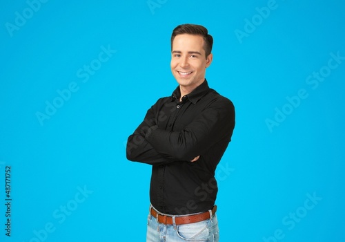 Cheerful Guy Smiling To Camera Posing Crossing Hands Standing Over Background.
