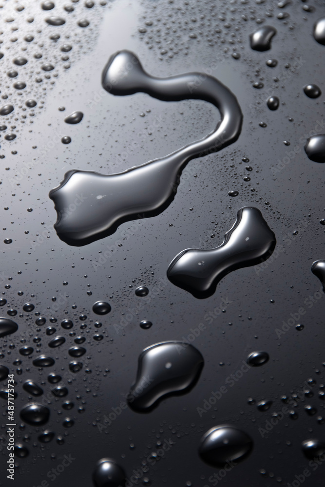 Black metal water drops on dark reflective surface Black metal water drops on dark reflective surface