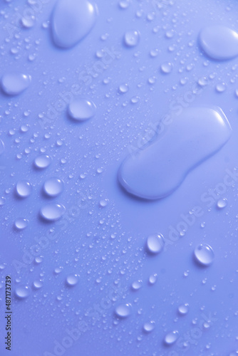 Blue pastel water drops on light shiny surface