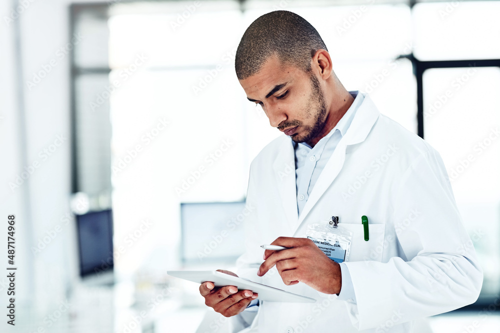 He likes to solve puzzles and problems. Shot of a scientist recording his findings on a digital tablet. He likes to solve puzzles and problems. Shot of a scientist recording his findings on a digital tablet.