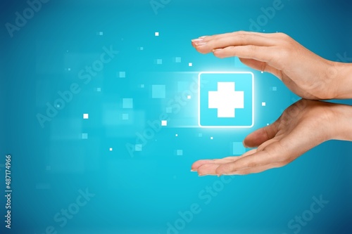 Person's hand holding plus icon on the background. Profit,health insurance, growth concepts.