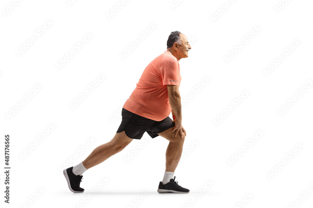 Full length profile shot of a mature man stretching his leg after exercise