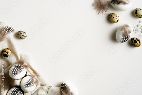 Happy Easter card design. Easter eggs decorated feathers on white background. Flat lay, top view. © photoguns