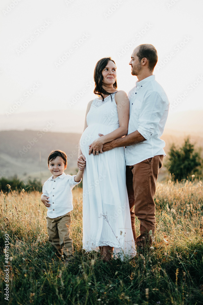 Happy pregnant woman holding his son and husband hands Happy pregnant woman holding his son and husband hands