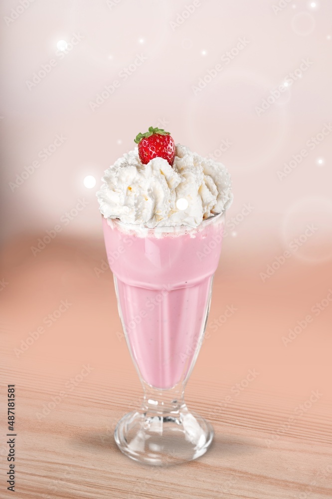 A glass of healthy strawberry smoothie with whipping cream on the desk A glass of healthy strawberry smoothie with whipping cream on the desk