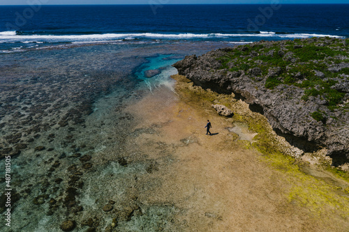 Man walks on the beach along edge of the ocean photo