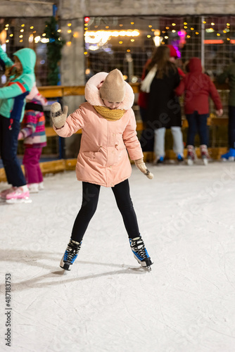 girl tries to skate on the ice rink