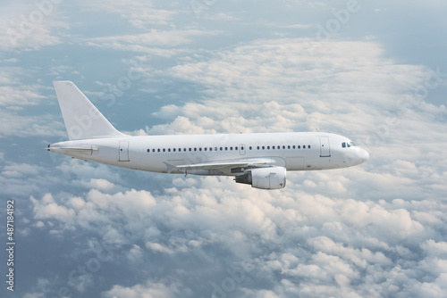 Side view of a passenger jet liner flying in the clouds.