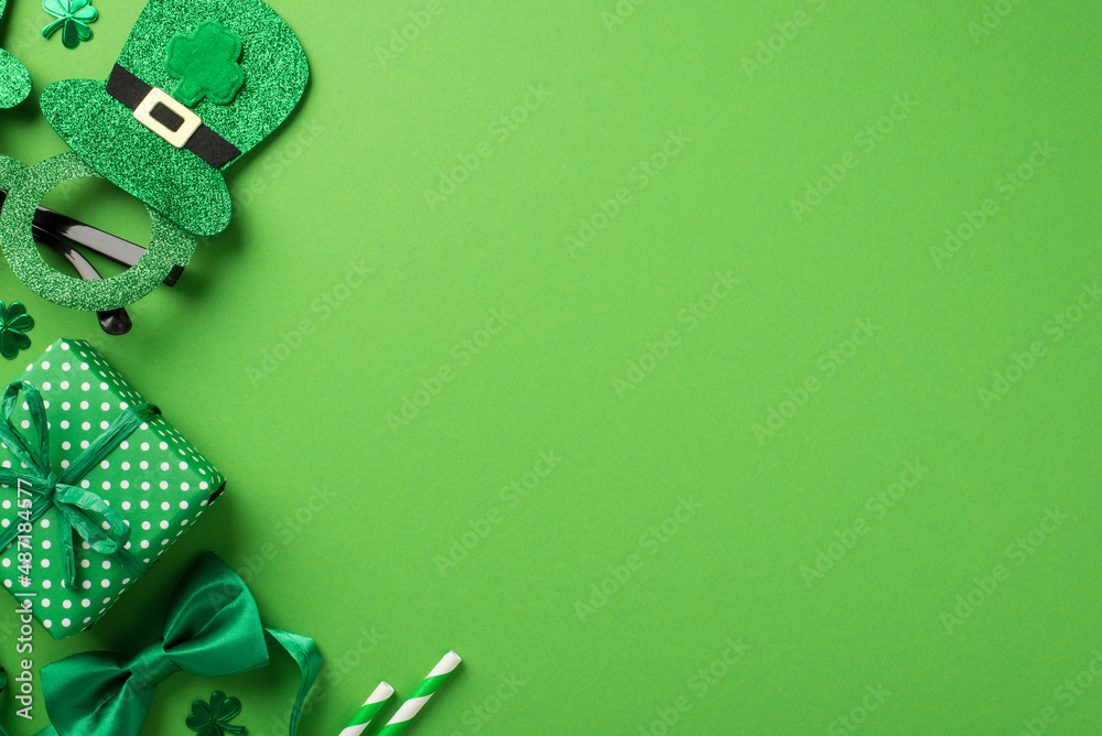 Top view photo of st patricks day decorations hat shaped party glasses green bow-tie shamrocks confetti straws and giftbox on isolated pastel green background with copyspace - obrazy, fototapety, plakaty 