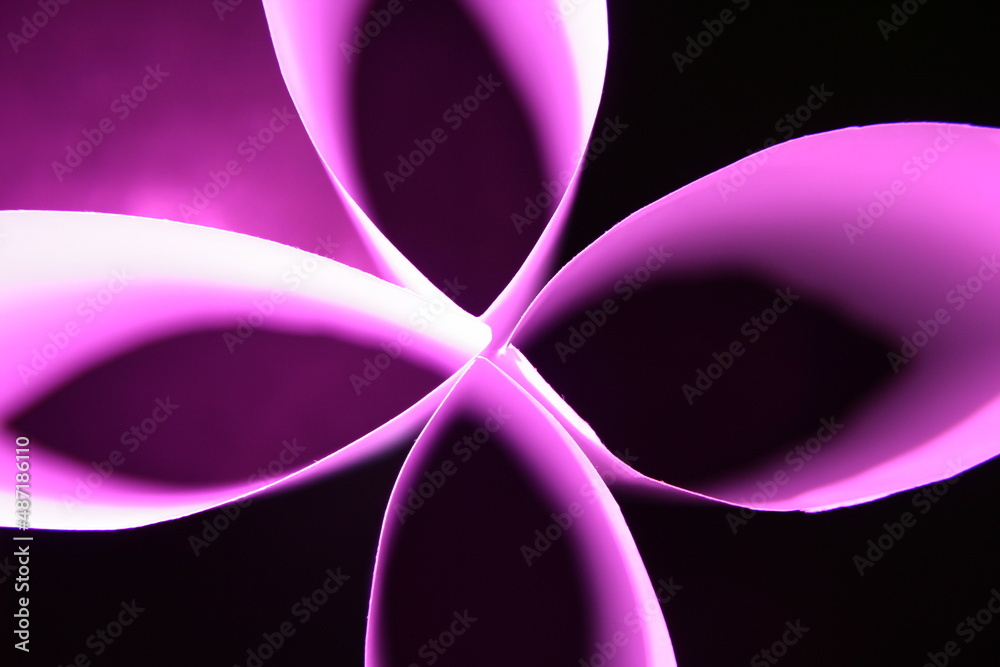 Flor de papel blanco para impresoras con luz de color violeta produce un hermoso diseño gràfico con pètalos en cruz con fondo negro. Flor de papel blanco para impresoras con luz de color violeta produce un hermoso diseño gràfico con pètalos en cruz con fondo negro.