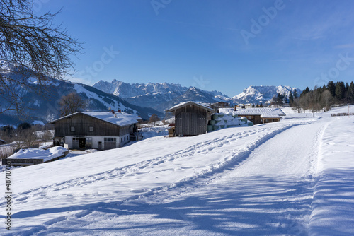 old bavarian farmer houses in the snow surrounded by high mountains in the winter © Sebastian