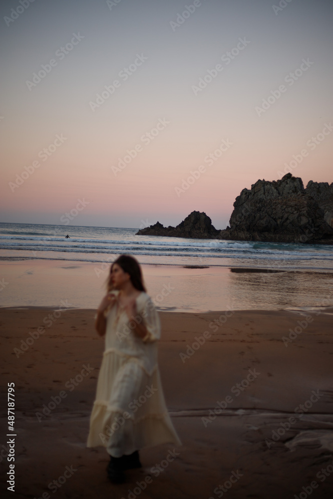 young girl enjoying the sunset on the beach in a long dress young girl enjoying the sunset on the beach in a long dress