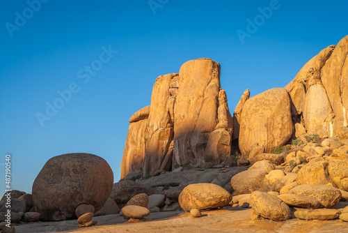 Landscape with eroded orange granite rocks against clear blue sky in central Namibia.
 photo