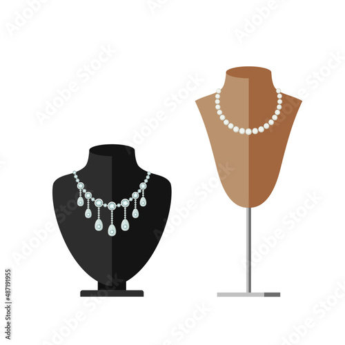 Necklace stands with jewellery on display. Black and beige busts with beads and necklace.