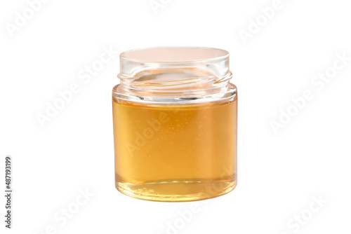 honey from a glass jar stands isolated on a white background