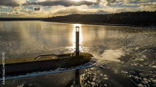 Aerial view of a pier with a lighthouse on a frozen lake